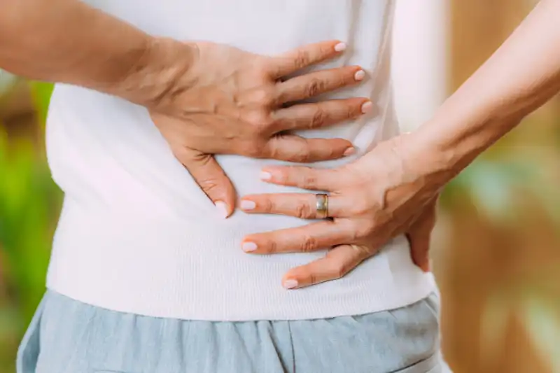 woman holding lower back in pain